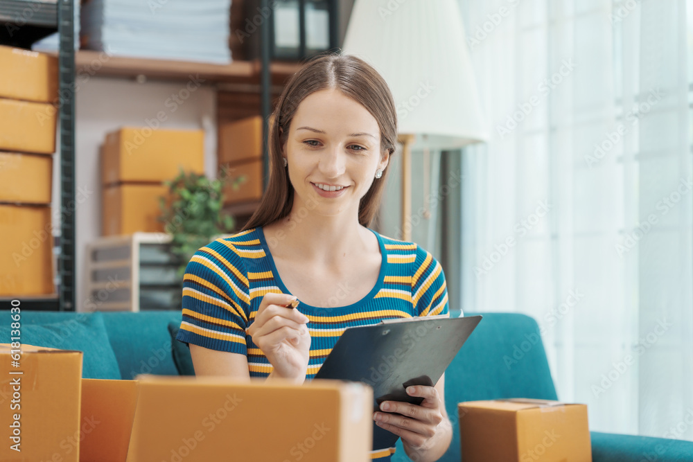 Startup small business entrepreneur SME or freelance woman using a laptop with box, Caucasian woman seller prepare parcel box of product for delivery to customer Online selling e-commerce SME concept Startup small business entrepreneur SME or freelance woman using a laptop with box, Caucasian woman seller prepare parcel box of product for delivery to customer Online selling e-commerce SME concept