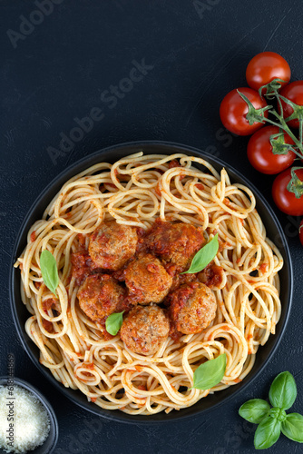 Spaghetti with meatballs and parmesan cheese on a black background. Italian pasta. Top view. Italian food.