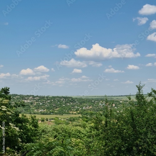 A view of a forest and blue sky with clouds