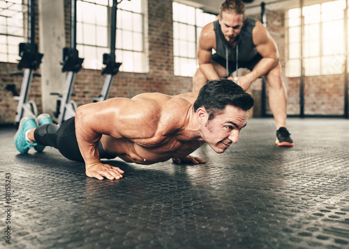 Fitness, personal trainer and athlete doing a push up exercise for strength, health and wellness. Sports, training and male person doing a body building arm workout with a coach for motivation in gym