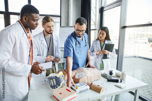 Canvas Print healthcare worker showing defibrillator, CPR manikin and medical equipment to yo