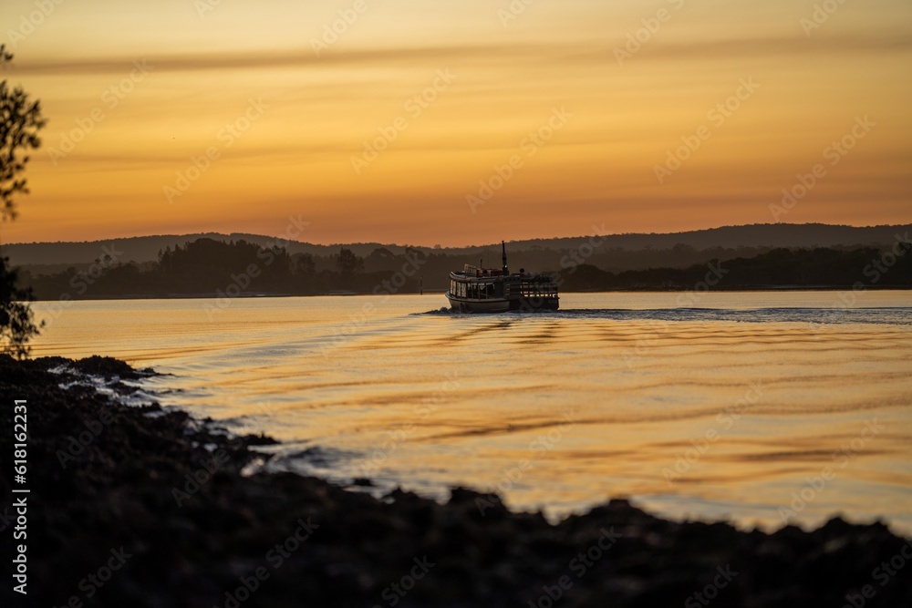 wooden ferry boat on a river crossing at sunset in australia