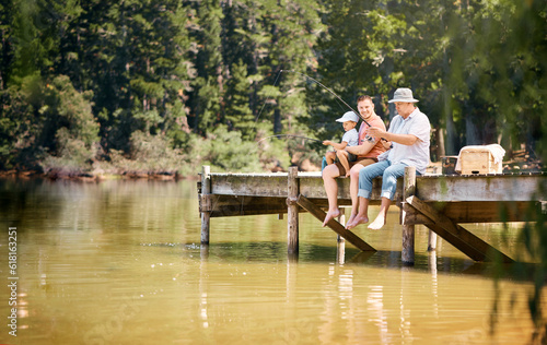 Father, grandfather and child fishing at lake together for fun bonding or peaceful time in nature outdoors. Dad, grandpa and kid enjoying life, catch or fish with rod by water pond or river in forest