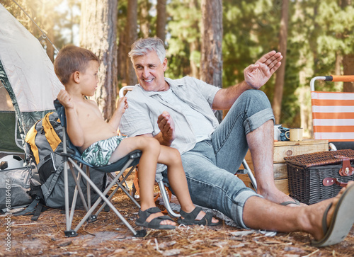 Child, senior man and camping outdoor in nature with a smile, fun and family travel for summer holiday. Happy grandpa and kid camper talking at a camp site, forest or woods with love for adventure