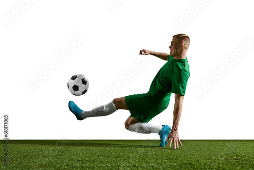 Young motivated man, football player in green uniform in motion, training, playing against white background. Concept of professional sport, action, lifestyle, competition, hobby, training, ad © master1305