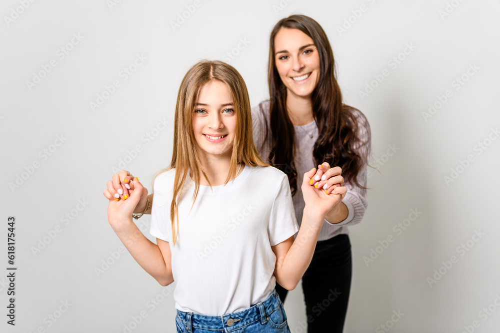 Confident mother and daughter standing in studio Confident mother and daughter standing in studio