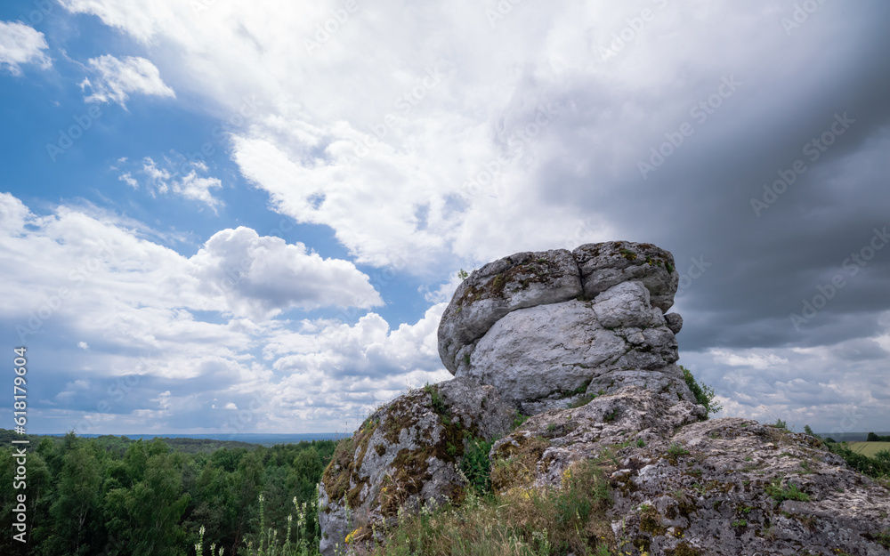 skały na tle ciemnych i jasnych chmur