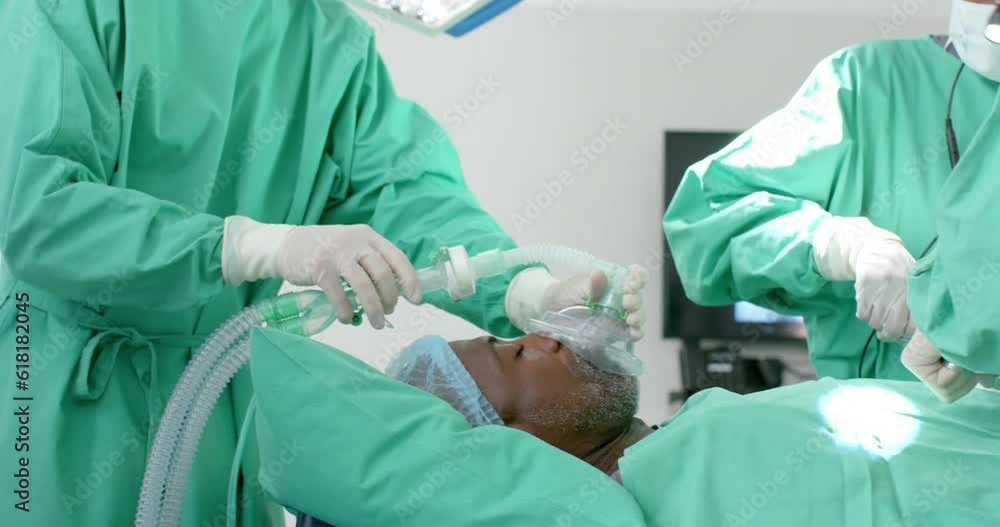Diverse surgeons giving anesthesia to patient in operating theatre, slow motion Diverse surgeons giving anesthesia to patient in operating theatre, slow motion