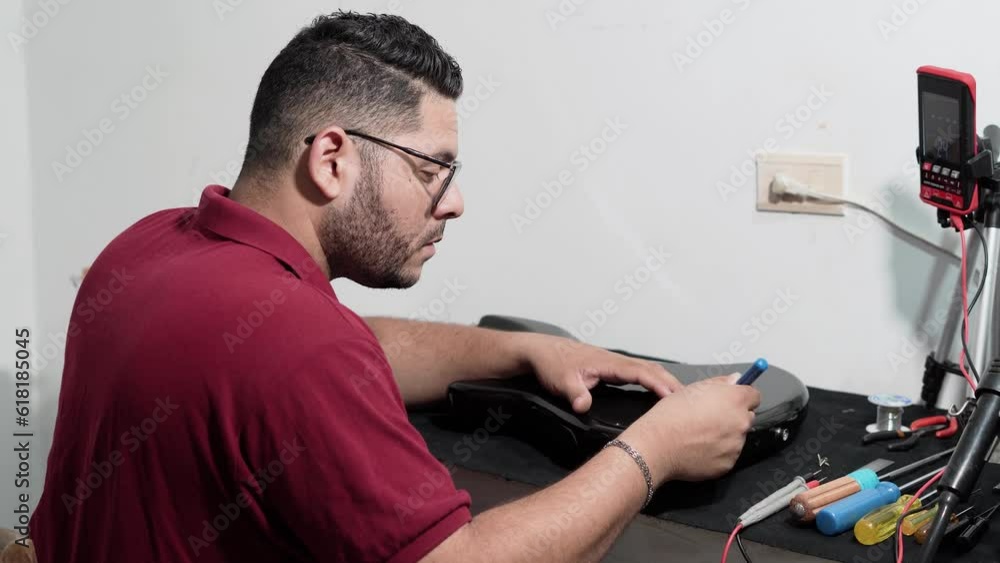 Professional electric man uncovering and checking wiring of electric guitar or electric bass - Luthier of musical instruments Professional electric man uncovering and checking wiring of electric guitar or electric bass - Luthier of musical instruments