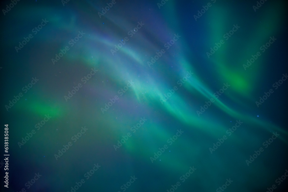 Aurora borealis or Northern lights glowing in the night sky on winter