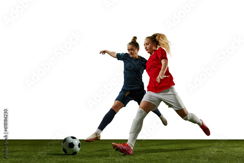 Two young girls, football players in motion, training, dribbling ball against white background. Sportschool. Concept of professional sport, action, lifestyle, competition and hobby, training, ad © master1305