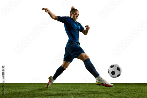 Dynamic image of female athlete, young girl, football player in motion with ball on sports field against white background. Concept of professional sport, action, lifestyle, competition, training, ad © master1305