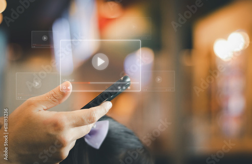 hand holding a phone to watch movie and watching live on virtual screen of multimedia platforms. concept of internet video streaming watch tv online , digital technology with content photo