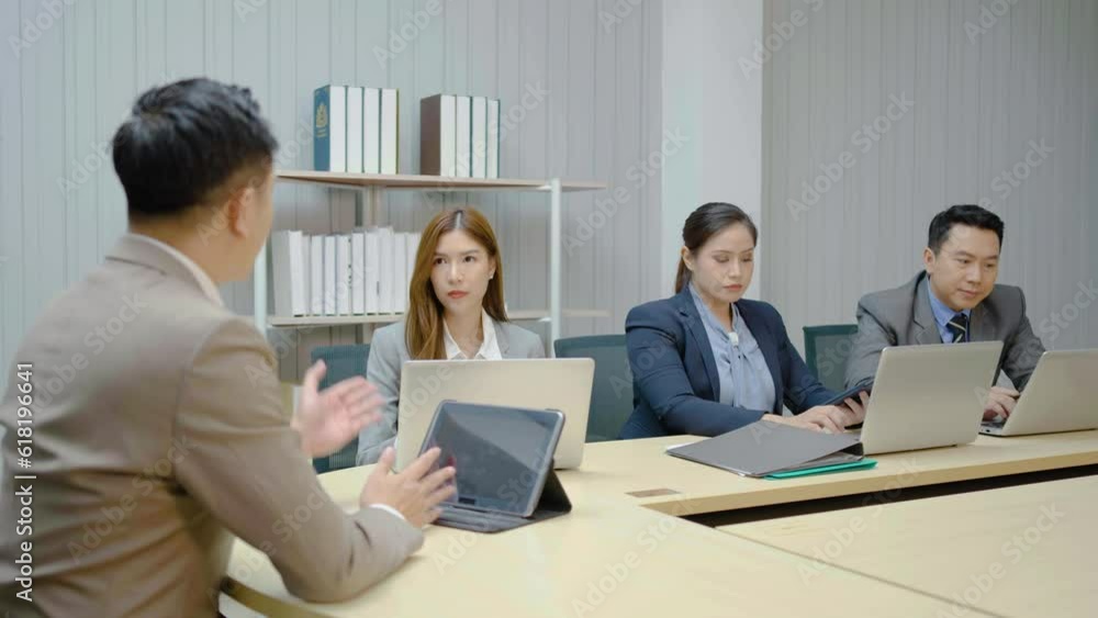 Smiling asian businessman boss executive talking to business people colleagues or partners sitting at conference table, male leader discussing work at team meeting or conversation with clients Smiling asian businessman boss executive talking to business people colleagues or partners sitting at conference table, male leader discussing work at team meeting or conversation with clients