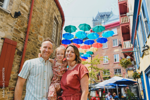 family in summer season in front of umbrella in quebec city