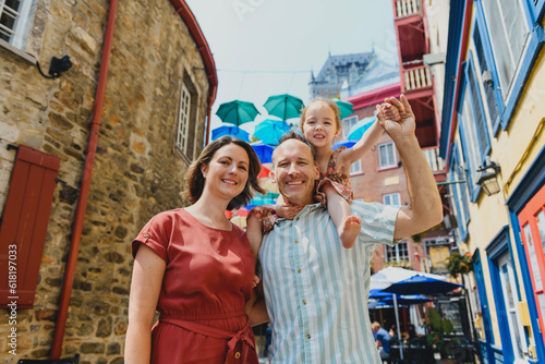 family in summer season in front of umbrella in quebec city