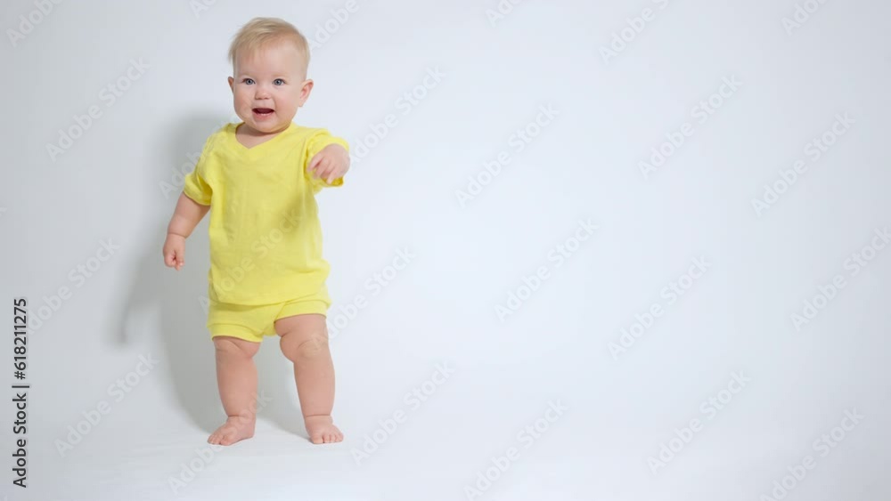 a smiling baby standing on its legs maintains balance with a positive emotion a smiling baby standing on its legs maintains balance with a positive emotion