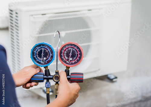 air conditioner repairman checking air conditioner measuring equipment for filling air conditioners.