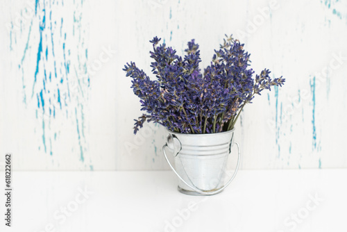 Fresh flowers of lavender bouquet in a bucket on a white wooden background