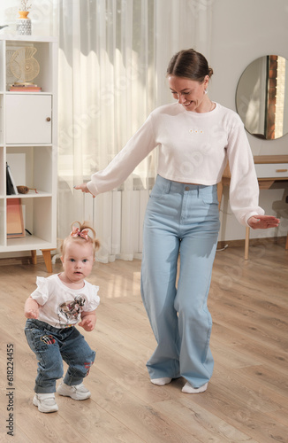 young beautiful woman dancing with her little daughter a home. Spending time and playing with children. happy family.