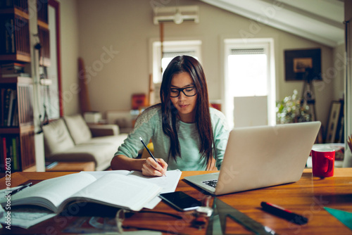 Young asian woman using a laptop and studying at home Free Download Young asian woman using a laptop and studying at home - GFXLoad
