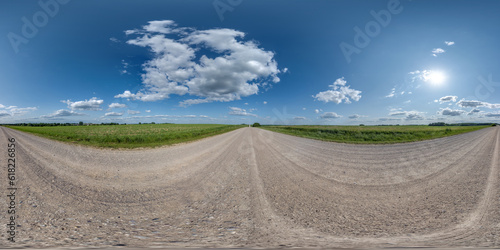 360 hdri panorama on gravel road with clouds and sun on blue sky in equirectangular spherical seamless projection, use as sky replacement in drone panoramas, game development sky dome or VR content