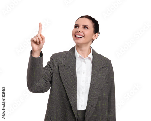 Beautiful businesswoman in suit pointing at something on white background