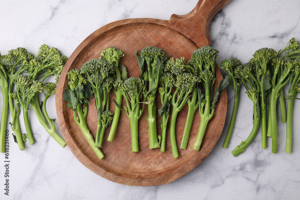 Fresh raw broccolini on white marble table, flat lay. Healthy food