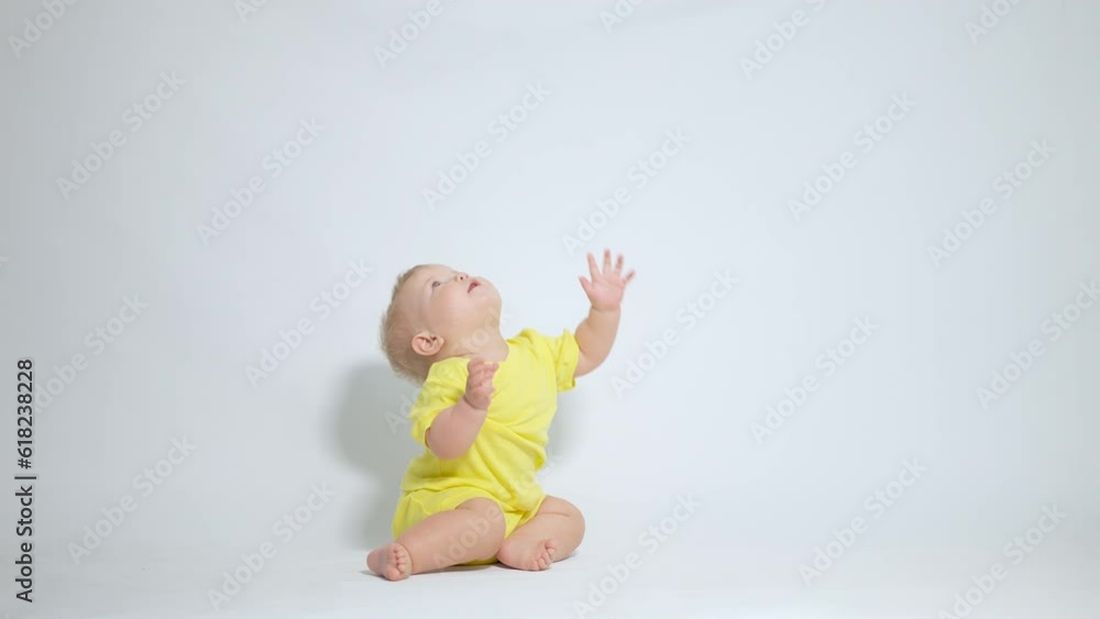 a child sitting on his ass reaches up with his hands trying to reach a child sitting on his ass reaches up with his hands trying to reach