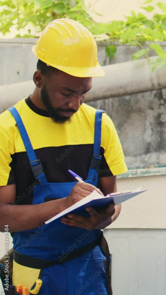 Vertical video Knowleadgeable engineer doing leak checks and other necessary fixes to prevent major HVAC system failures. Efficient technician verifying air conditioner, writing findings on clipboard Vertical video Knowleadgeable engineer doing leak checks and other necessary fixes to prevent major HVAC system failures. Efficient technician verifying air conditioner, writing findings on clipboard