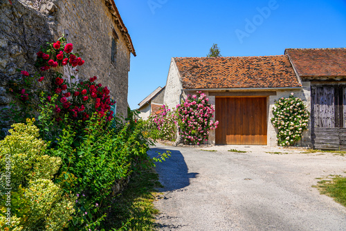 Street decorated with colorful flowers in Yèvre le Châtel, a medieval village located in the French department of Loiret, Centre Val de Loire, France