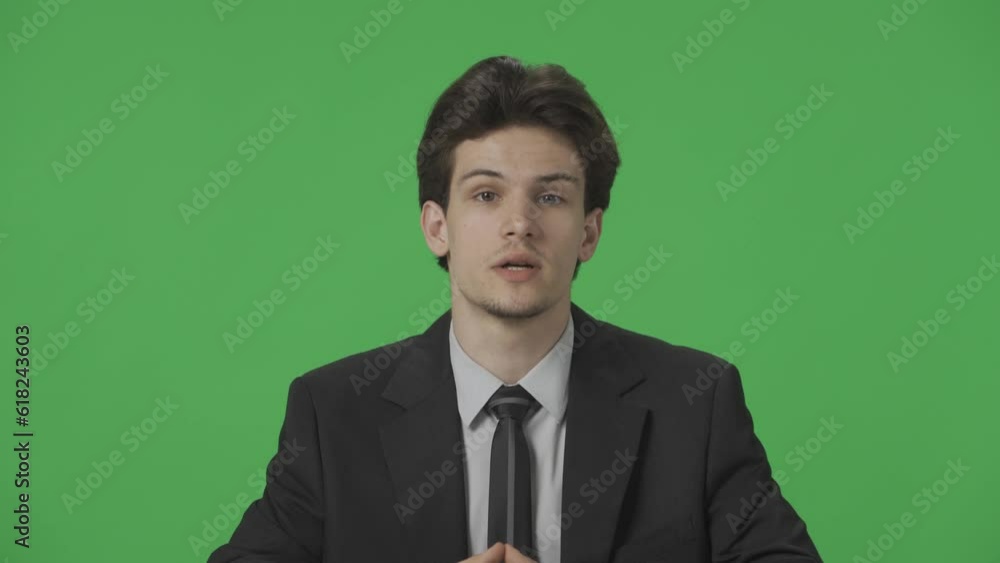 TV studio live news program with green screen background. A TV presenter speaks confidently as he covers the day's events close up. Advertising area, workspace mock up. HDR BT2020 HLG Material. TV studio live news program with green screen background. A TV presenter speaks confidently as he covers the day's events close up. Advertising area, workspace mock up. HDR BT2020 HLG Material.