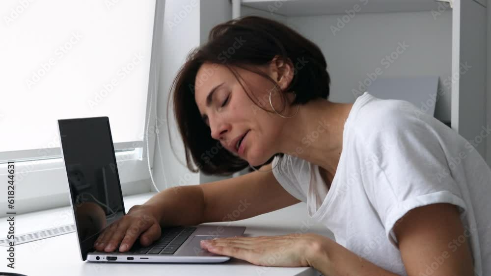 Tired, frustrated, exhausted, stressed woman yawns and sleeping on laptop keyboard, sitting at desk. Headache. Daylight work. Tired, frustrated, exhausted, stressed woman yawns and sleeping on laptop keyboard, sitting at desk. Headache. Daylight work.