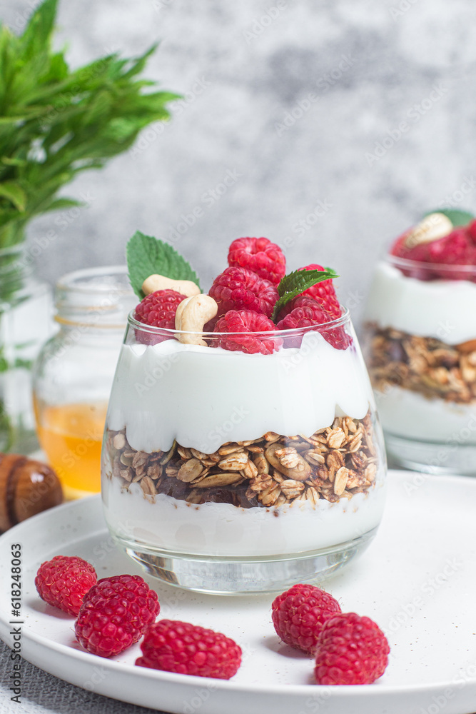 Granola with yogurt and raspberries in a glass Granola with yogurt and raspberries in a glass