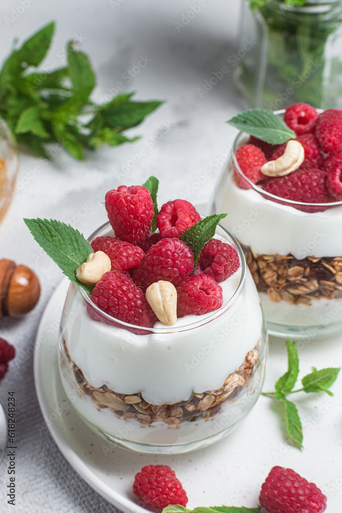 Granola with yogurt and raspberries in a glass Granola with yogurt and raspberries in a glass