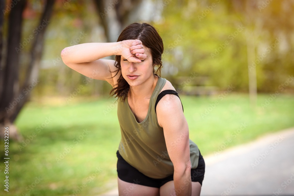 Female Runner Jogging during Outdoor Workout in a Park Female Runner Jogging during Outdoor Workout in a Park