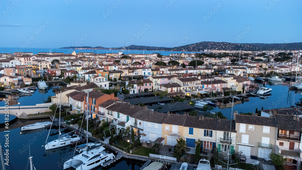Port Grimaud harbor in France in springtime with yachts and sailboats and Mediterranean Sea in the evening, drone shot, Cote d'Azur