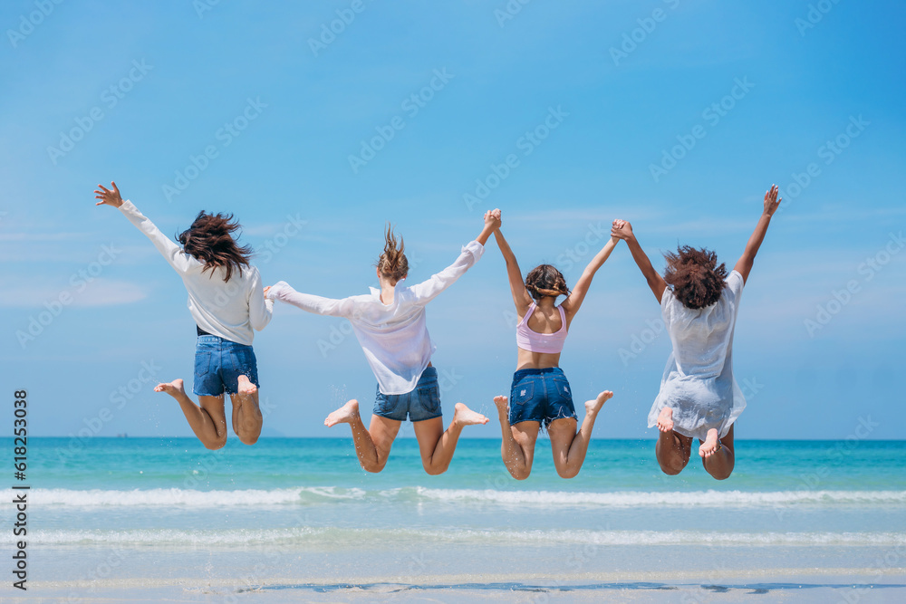 Happy childrens jumping on sand at beach. Teens playing and enjoying with friends at the sea. Vacations time and friendship concept. Happy childrens jumping on sand at beach. Teens playing and enjoying with friends at the sea. Vacations time and friendship concept.