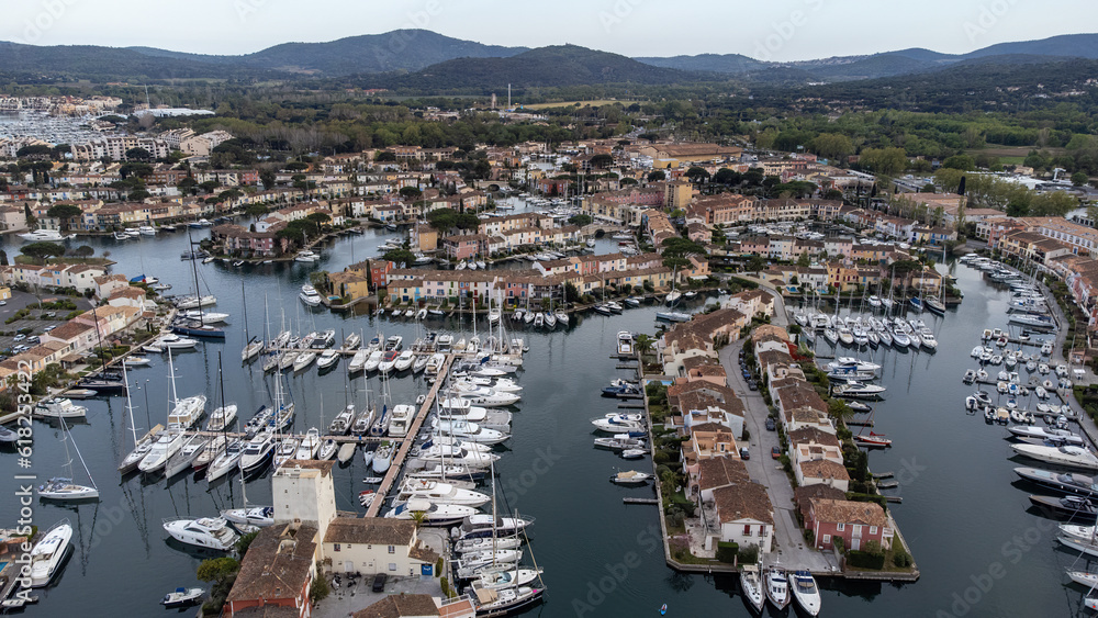 Port Grimaud harbor in France in springtime with yachts and sailboats and Mediterranean Sea by day, drone shot, Cote d'Azur