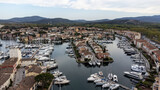 Port Grimaud harbor in France in springtime with yachts and sailboats and Mediterranean Sea by day, drone shot, Cote d'Azur
