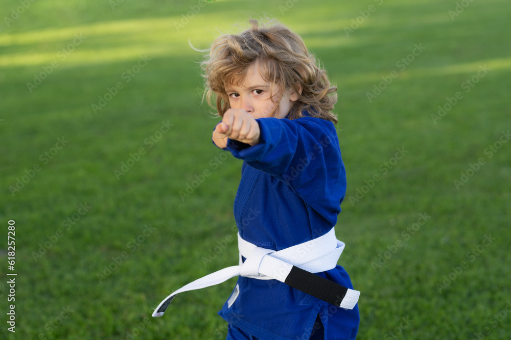 Kid boy practicing karate outdoor. Sport karate kids. Little boy