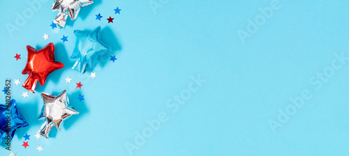 4th of July, USA Presidents Day, Independence Day. Flat lay top view of celebration decor inflatable star balloons twinkling confetti on blue background, promotion or greeting message, banner