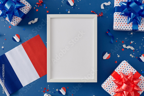 Bastille Day commemoration concept. Top view composition of patriotic presents, french flag, hearts, colorful glitter on blue background with empty frame for advert or text