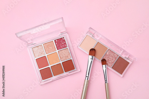 Konstfotografi Beautiful eye shadow palettes and brushes on pink background, flat lay