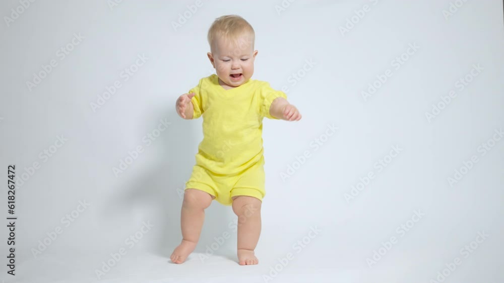 the baby diligently takes the first steps while maintaining balance the baby diligently takes the first steps while maintaining balance