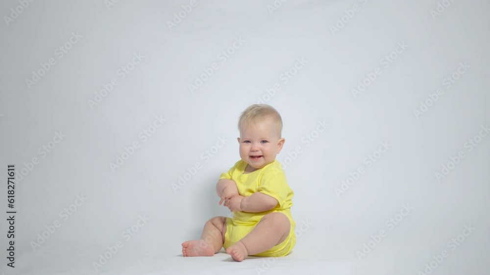 the baby sitting on the ass shyly smiles the baby sitting on the ass shyly smiles