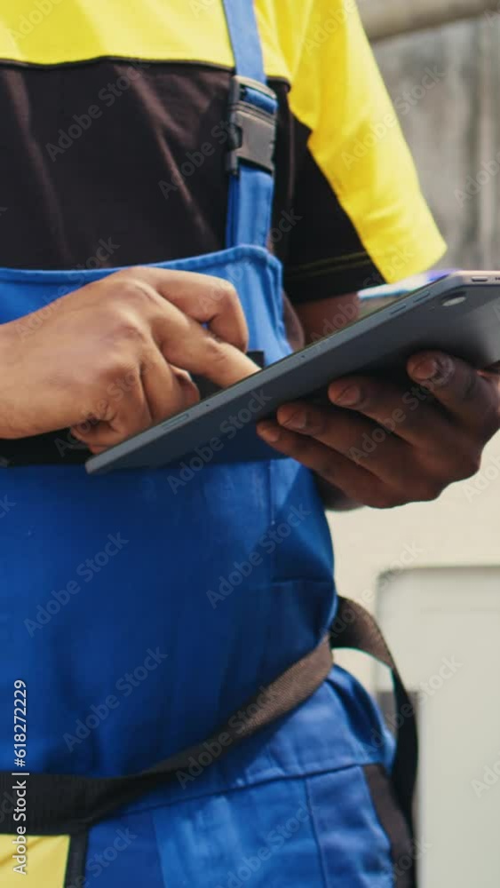 Vertical video Close up of skillful technician commissioned for outside hvac system routine maintenance, looking for refrigerant issues. Meticulous mechanic doing air conditioner inspection, writing Vertical video Close up of skillful technician commissioned for outside hvac system routine maintenance, looking for refrigerant issues. Meticulous mechanic doing air conditioner inspection, writing
