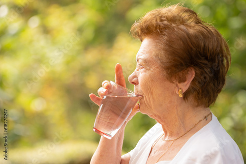 senior drinking water in summer outdoors photo