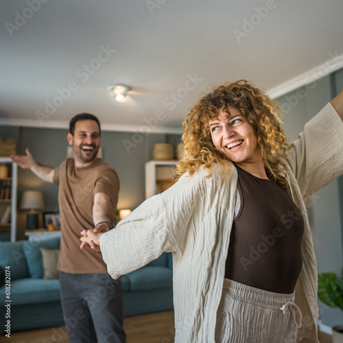 Happy couple adult caucasian man woman husband and wife dance at home
