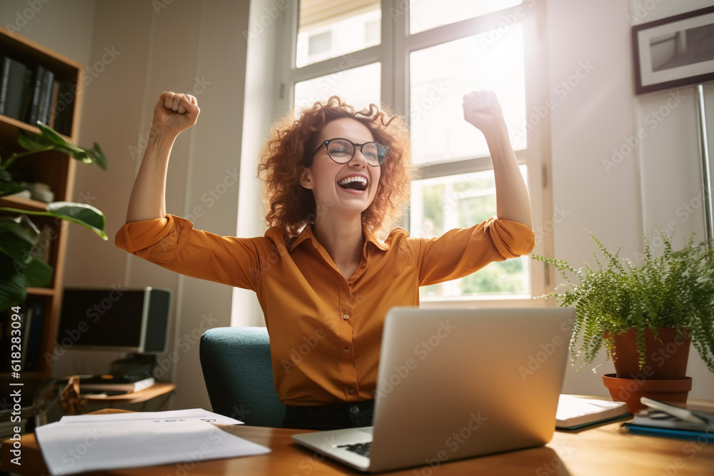Joyful business woman freelancer entrepreneur smiling and rejoices in victory while sitting at desk and working at laptop after finishing project in home office. High quality photo - obrazy, fototapety, plakaty 